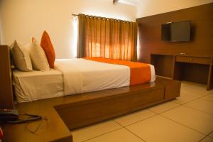 a bedroom with a bed and a television in it at YELLOW LAKE RESORTS & SPA, Yercaud in Yercaud