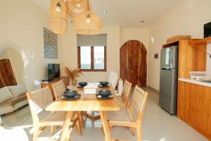 cocina y comedor con mesa de madera y sillas en Felgio Villa Jimbaran en Ungasan