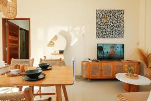 sala de estar con mesa y TV en Felgio Villa Jimbaran en Ungasan