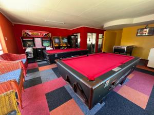 a room with two pool tables and arcade games at #One6Eight in Hermanus