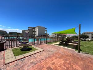 a park with a bench and a green umbrella at #One6Eight in Hermanus