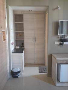 a kitchen with white cabinets and a tv in it at Omaxe krishna luxury stays in Vrindāvan