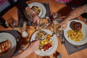 een groep mensen die wijn drinken aan een tafel met eten bij carpe solem KAPOOM - Branded Apartments incl Zell am See-Kaprun Summer Card in Kaprun