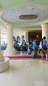 eine Gruppe von Menschen, die in einer Lobby mit Säulen stehen in der Unterkunft Resort Sur Beach Holiday in Sur