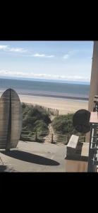 - une vue sur la plage avec un bâtiment et l'océan dans l'établissement 2 Bed Beach-House. Footsteps to Seafront & SA1 Marina, à Swansea