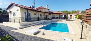 a swimming pool in front of a house at Beach Villa in Saint Epiktitos