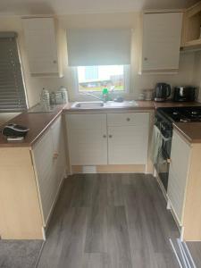 a kitchen with white cabinets and a sink and a window at BLW 04 in Great Billing