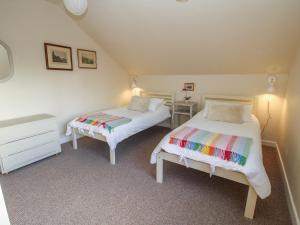 1 dormitorio con 2 camas y vestidor en Brynlikky Cottage, en Bucknell