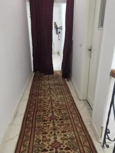 un couloir avec un tapis au sol et une corridorngthngthngthngthngthngth dans l'établissement Heliopolis Roxy, au Caire