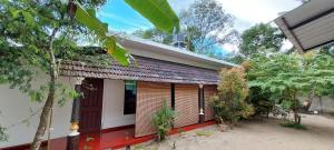 une maison d'hôtes avec une porte rouge et des arbres dans l'établissement Marari Lois Beach Homes, à Mararikulam