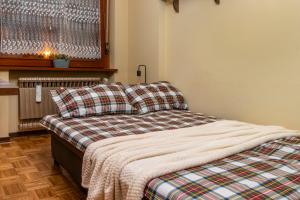um quarto com uma cama com um cobertor xadrez em BeSt Volpe em Sestriere
