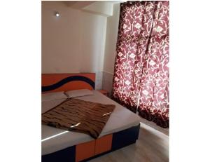 - un petit lit dans une chambre avec rideau dans l'établissement Hotel New Green View, Katra, à Katra
