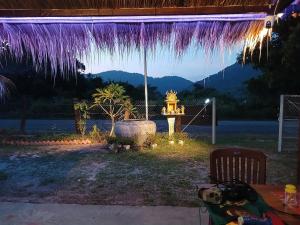 a fire hydrant in a backyard at night with purple lights at Le Soleil in Kep