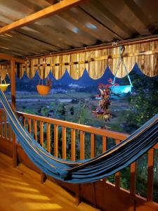 a hammock on a balcony with a painting of a field at Panchas Retreat Homestay in Kāskī