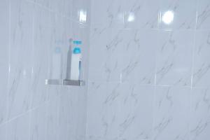 La salle de bains est pourvue d'une douche et de carrelage en marbre blanc. dans l'établissement Tulivu homes, 