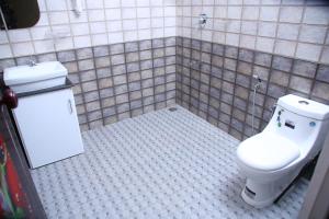 La salle de bains est pourvue de toilettes et de carrelage. dans l'établissement Marari Lois Beach Homes, à Mararikulam