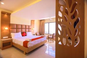 um quarto de hotel com uma cama e uma secretária em Hotel Sangam em Kanyakumari