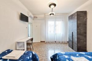 Schlafzimmer mit einem Bett, einem Schreibtisch und einem Fenster in der Unterkunft City Living Guest House Venice in Mestre