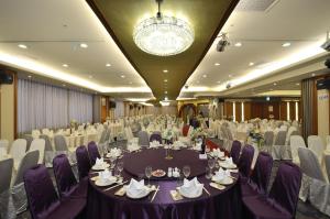 un salón de banquetes con mesas y sillas y una lámpara de araña en Hotel RegaLees, en Tamsui