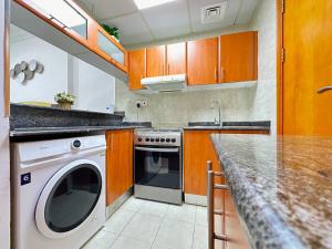 une cuisine avec un lave-linge et un comptoir dans l'établissement Brand New Studio w/ Balcony in center of Marina, à Dubaï