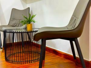 Deux chaises et une table avec une plante sur la table dans l'établissement Brand New Studio w/ Balcony in center of Marina, à Dubaï
