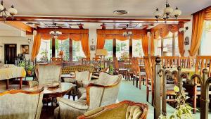 a restaurant with chairs and tables and windows at Pensiunea Mai in Păltiniş