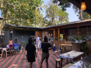 a group of people standing outside of a house at Bibhitaki Hostels Palolem Beach in Palolem