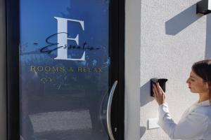 Uma mulher está a abrir uma porta com o telemóvel. em Essentia Rooms & Relax em Vasto