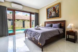 a bedroom with a large bed and a large window at Azure House - the dive to bright holiday in Ubud