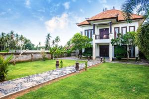 a house with a green lawn in front of it at Azure House - the dive to bright holiday in Ubud