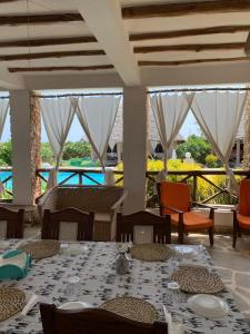 a dining room with tables and chairs with a view at Coral Village in Malindi