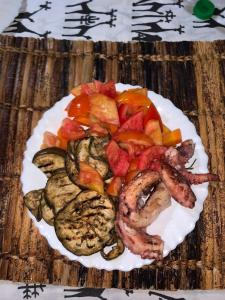 einen Teller mit Garnelen und Gemüse auf dem Tisch in der Unterkunft Coral Village in Malindi