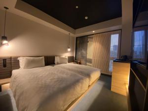 a bedroom with a large bed and a television at Hotel Resol Trinity Osaka in Osaka