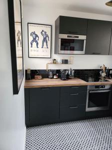 a kitchen with black cabinets and a counter top at La maisonnette des hautes granges in Blois