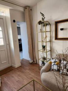 a living room with a chair and a shelf with plants at La maisonnette des hautes granges in Blois