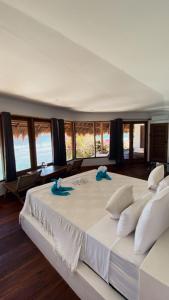 a large white bed with two blue towels on it at Rock'n Reef in Uluwatu