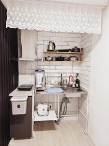 una pequeña cocina con fregadero y encimera en MO Guesthouse en Jeju