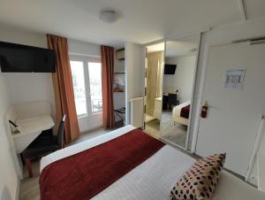 een hotelkamer met een bed en een spiegel bij Logis Hôtel Les Bleuets in Royan