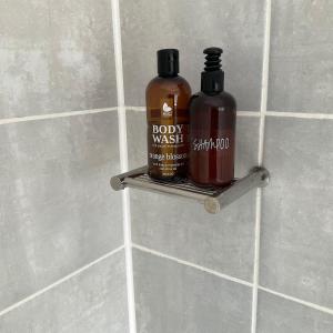 two bottles of hot sauce sitting on a shelf in a bathroom at Contemporary unit at the Blyde in Pretoria