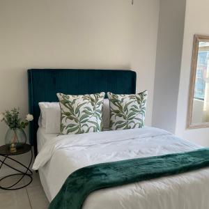 a bed with a green headboard in a bedroom at Contemporary unit at the Blyde in Pretoria