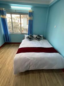 um quarto com uma cama grande e paredes azuis em Sagarmatha View Homes em Kathmandu