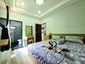 una camera da letto con un grande letto con asciugamani di Comfy house near sunset beach a Ko Samui