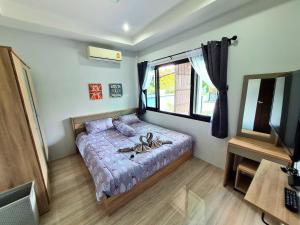 a bedroom with a bed and a window at Comfy house near sunset beach in Koh Samui
