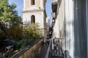 een uitzicht vanuit een raam van een gebouw met een klokkentoren bij O' Munasterio e Santa Chiara in Napels