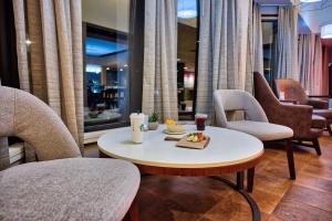 um quarto com cadeiras e uma mesa com uma bandeja de comida em Courtyard Hampton em Hampton