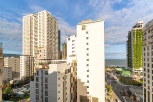 vistas a una ciudad con edificios altos y al océano en May Beach Hotel en Da Nang