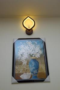 a picture of a vase on a table with a clock at Hotel Elite Inn in Srikalahasti