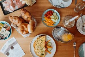 una mesa de madera cubierta con platos de comida y pan en Der Löffler am Semmering Bed&Breakfast, en Semmering