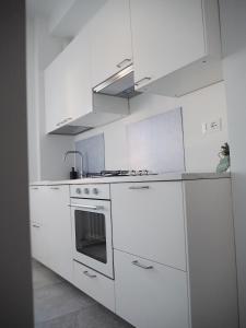 a white kitchen with a stove and a sink at Ceccarini 2023 in Riccione