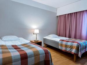 a hotel room with two beds and a window at Hotel Sommelo in Kouvola